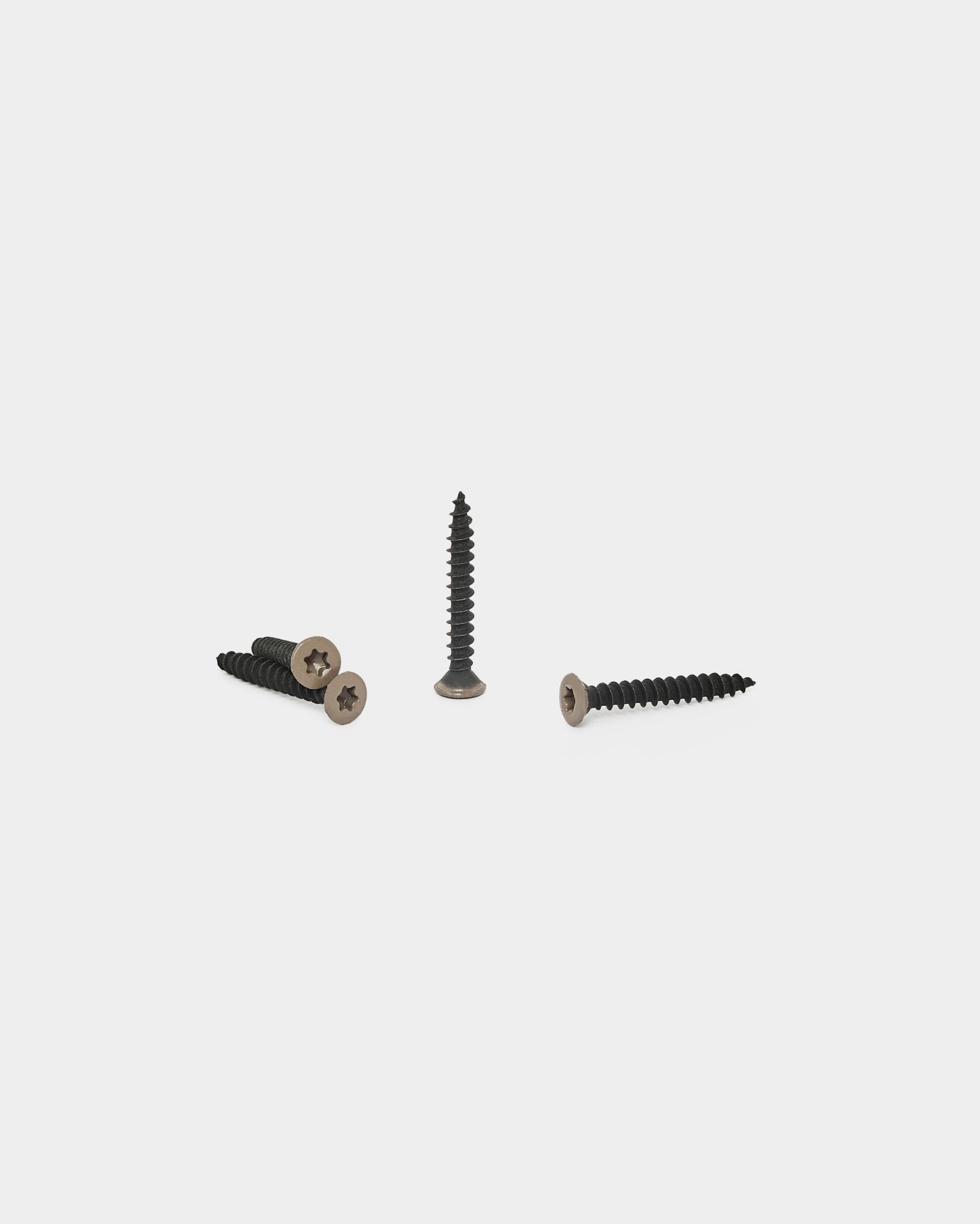 Three warm grey screws for WoodUpp acoustic panels are arranged on a white background, one standing upright and two lying flat with heads visible.
